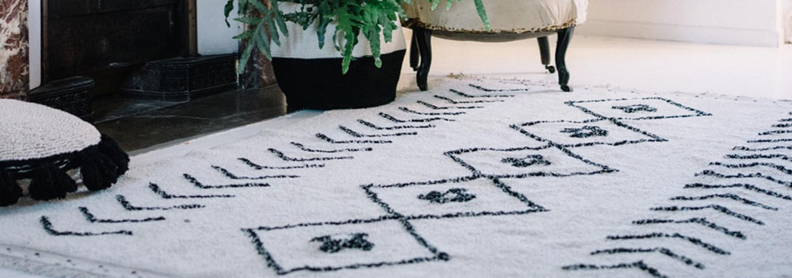 tapis marocain avec des motifs de losanges dans un salon moderne près d'une cheminée